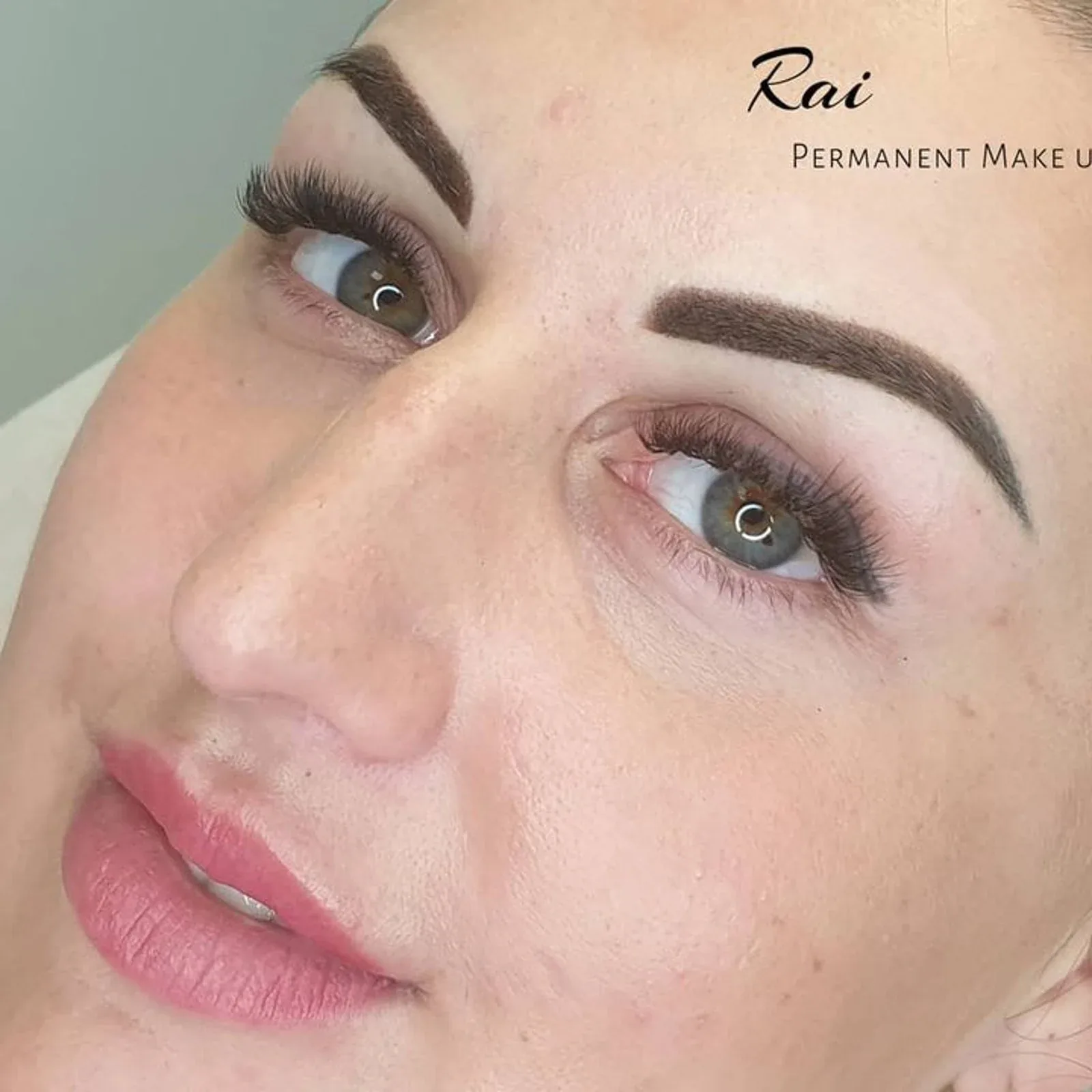 Defined ombre brows with a crisp tail, photographed from below with lash extensions