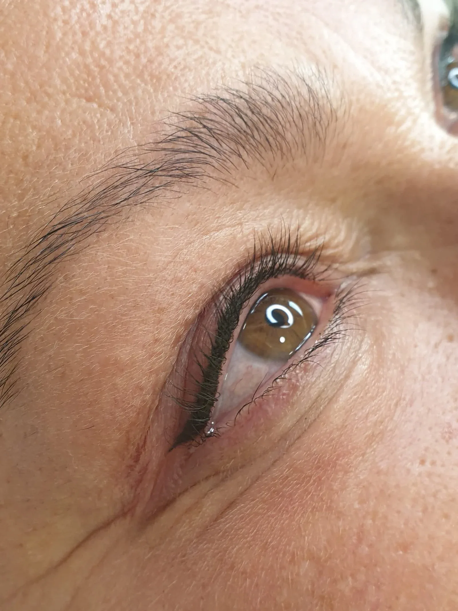 Close-up of permanent eyeliner tight to the lash line for a natural finish