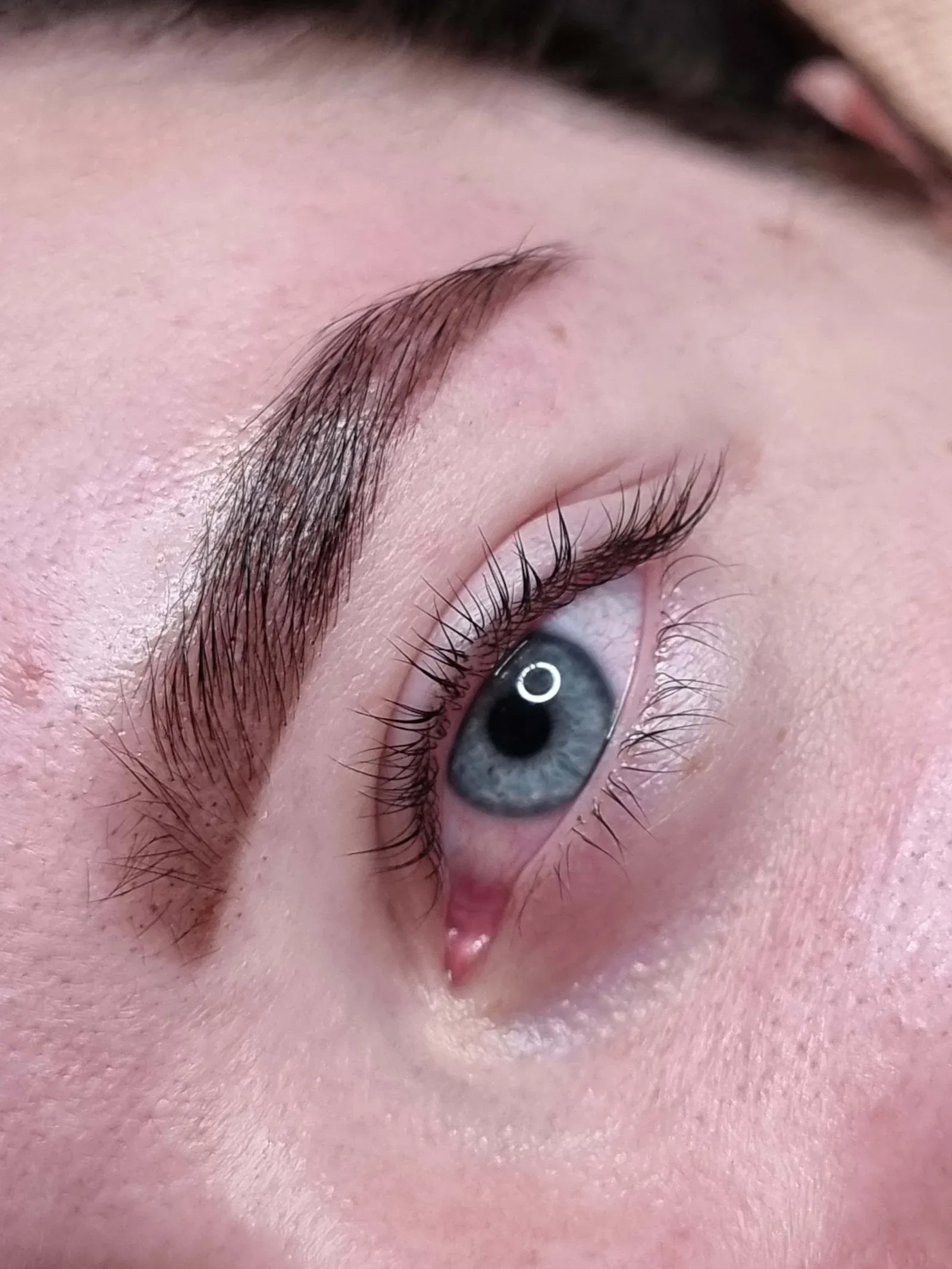 Lash lift and brow tint on blue eyes, with lashes curled up from the lash line